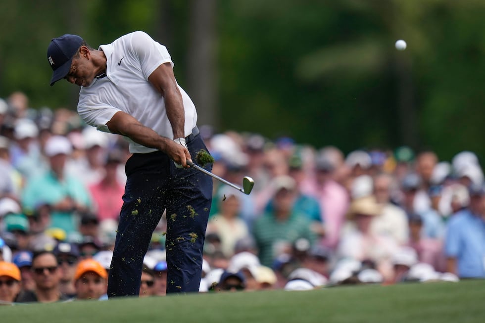 Tiger Woods hits his tee shot on the 12th hole during the first round of the Masters golf...