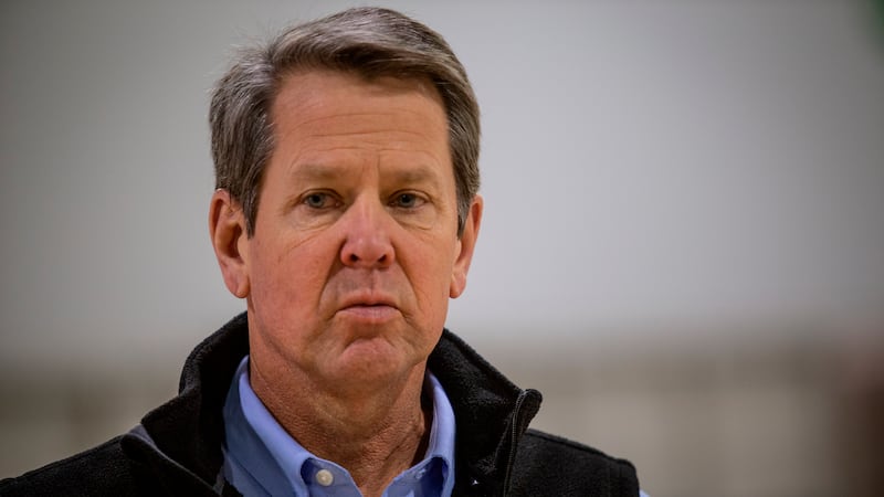 Georgia Gov. Brian Kemp listens to a question from the press during a tour of a massive...
